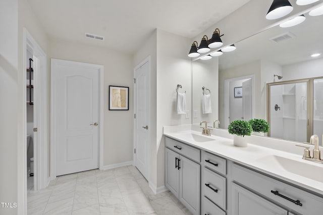 bathroom with marble finish floor, visible vents, and a sink