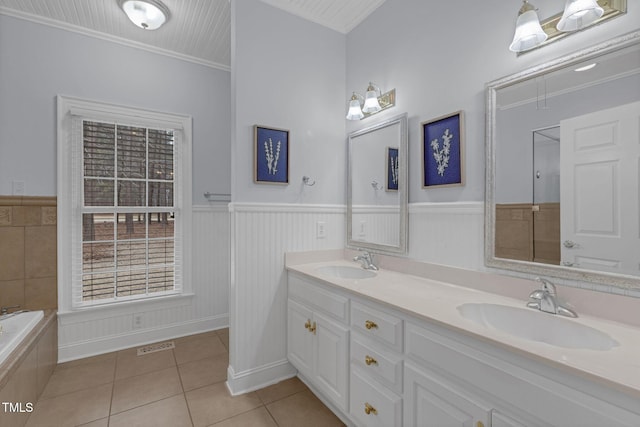 bathroom featuring a wainscoted wall, ornamental molding, a sink, and tile patterned floors