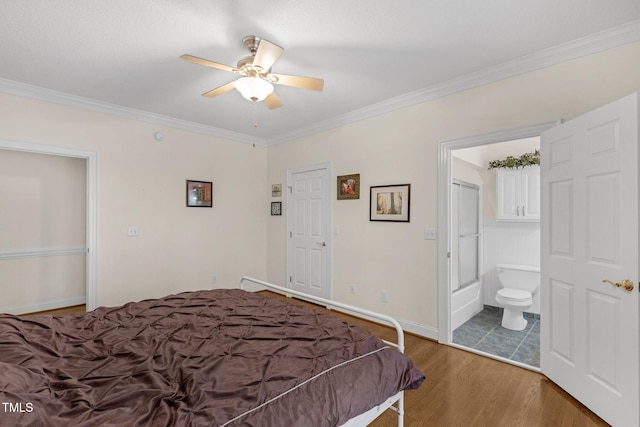 bedroom featuring ensuite bathroom, baseboards, wood finished floors, and crown molding