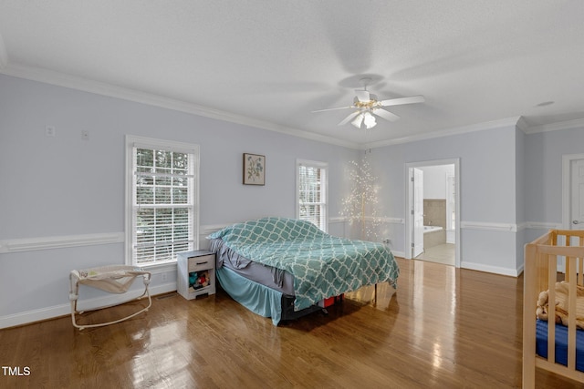 bedroom featuring a ceiling fan, crown molding, baseboards, and wood finished floors