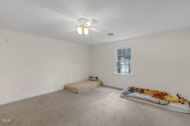 unfurnished bedroom with baseboards, carpet, visible vents, and a textured ceiling