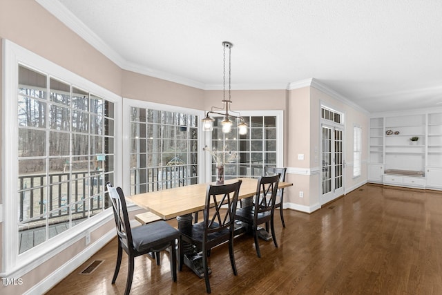 dining area featuring built in features, baseboards, visible vents, and wood finished floors