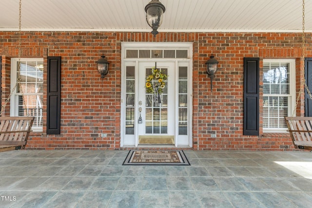 doorway to property featuring brick siding