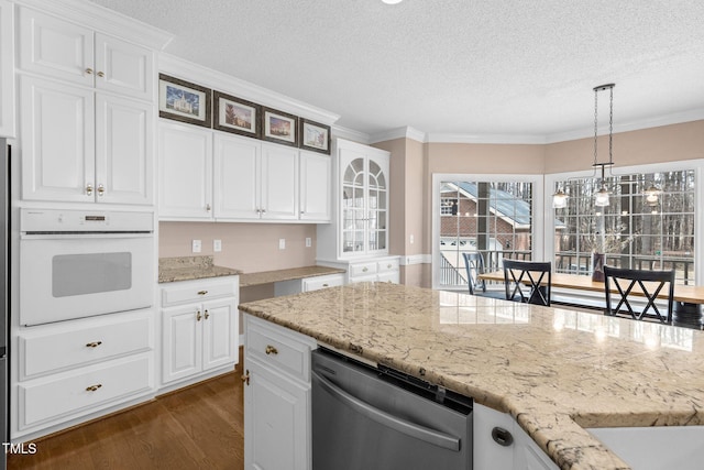 kitchen featuring oven, dark wood-type flooring, white cabinetry, glass insert cabinets, and crown molding