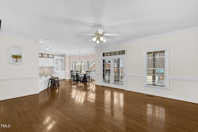 unfurnished living room with dark wood-type flooring, visible vents, and ornamental molding