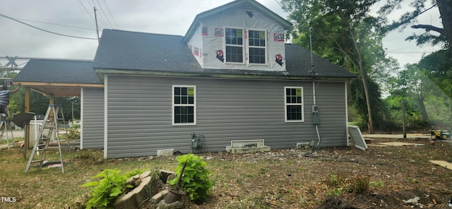 rear view of property with a shingled roof