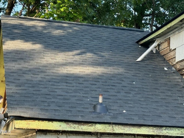 exterior details featuring roof with shingles