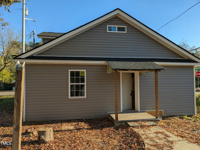 rear view of house featuring a shingled roof