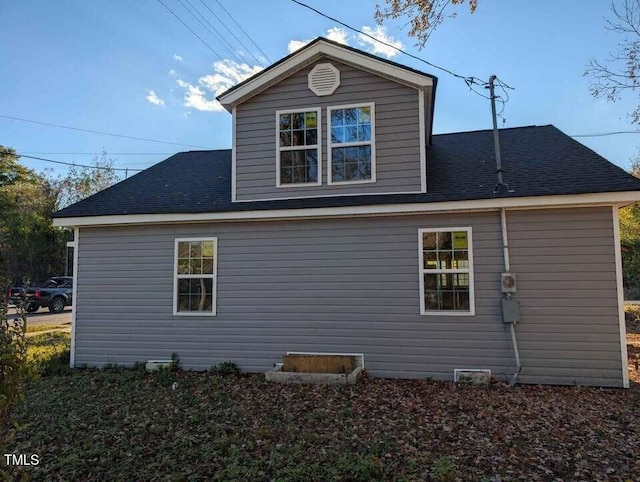 back of property featuring roof with shingles