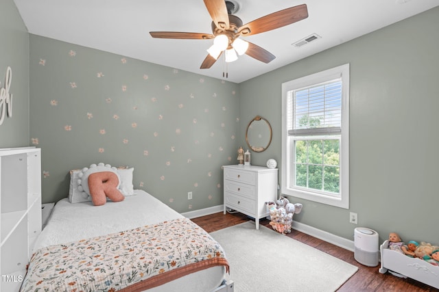 533 E Maple Ave, Holly Springs, NC 27540 - bedroom featuring multiple windows, wood finished floors, wallpapered walls, and a ceiling fan