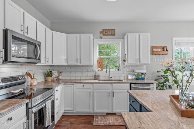 533 E Maple Ave, Holly Springs, NC 27540 - kitchen featuring stainless steel appliances, white cabinets, dark wood-type flooring, backsplash, and light stone countertops