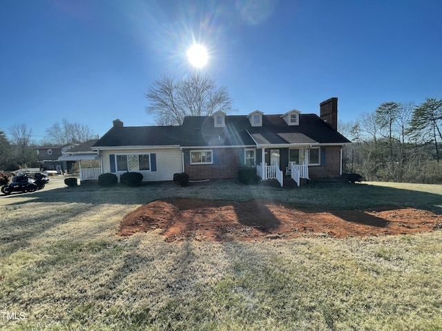 cape cod home with brick siding, a chimney, and a front lawn