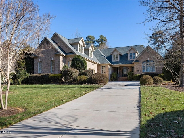 view of front of house with concrete driveway, brick siding, and a front yard