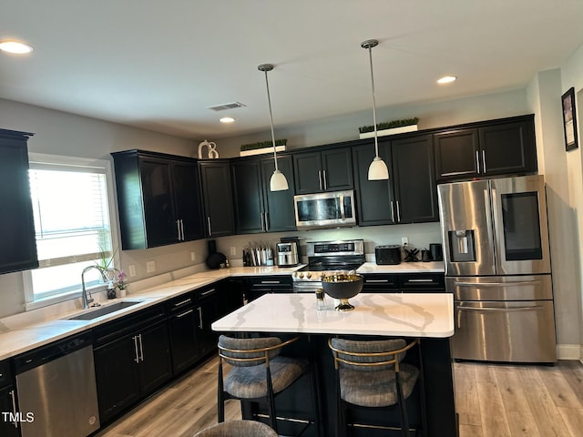 kitchen featuring visible vents, dark cabinetry, appliances with stainless steel finishes, and a sink