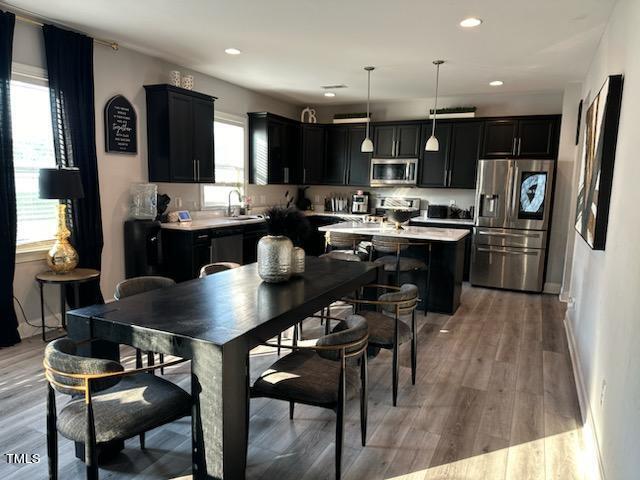 dining room with baseboards, light wood-type flooring, and recessed lighting