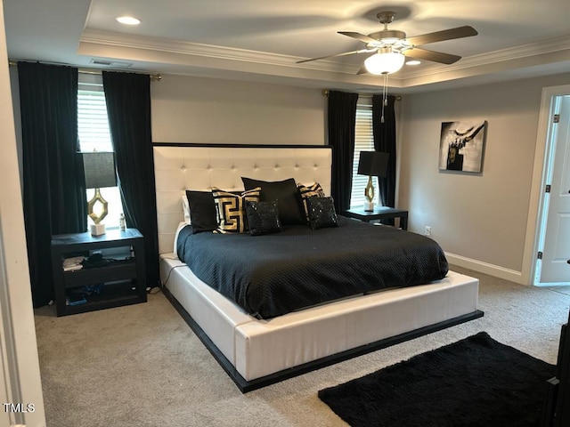 bedroom with baseboards, ornamental molding, a raised ceiling, and carpet flooring