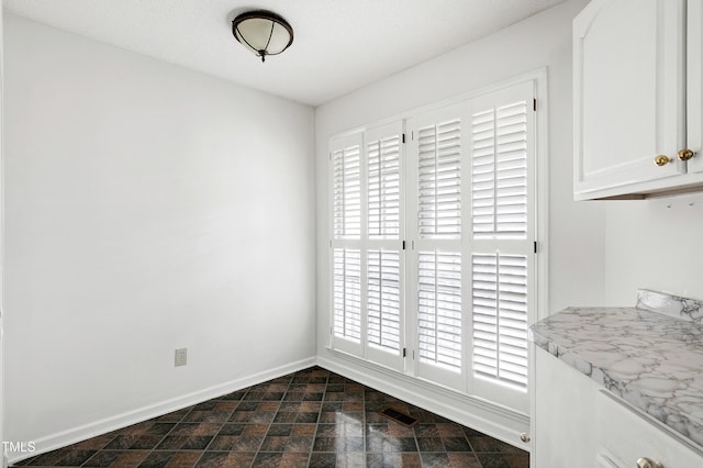 dining room with stone finish floor and baseboards