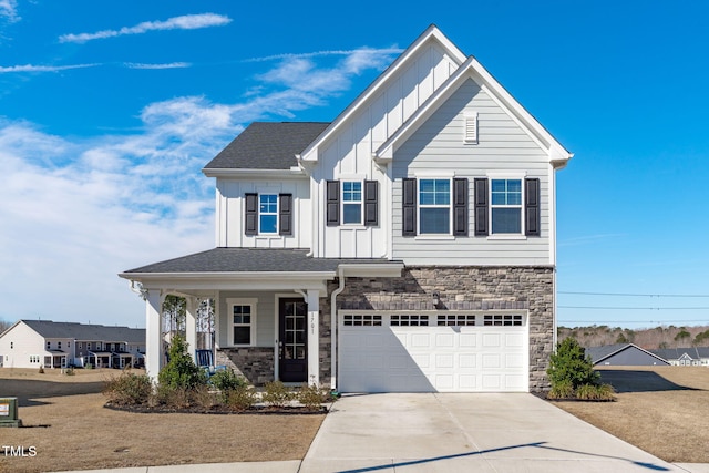 view of front facade featuring an attached garage, covered porch, stone siding, driveway, and board and batten siding