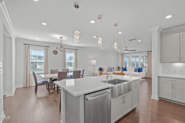 kitchen featuring a sink, crown molding, open floor plan, and dishwasher