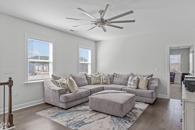 living area with ceiling fan, wood finished floors, visible vents, and baseboards