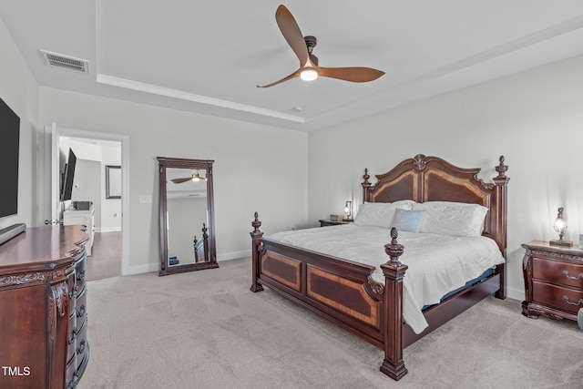 bedroom with light colored carpet, a ceiling fan, baseboards, visible vents, and a raised ceiling