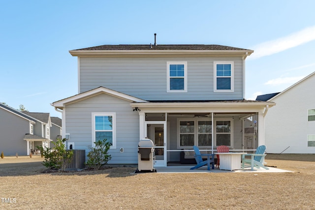 rear view of house with central AC unit, a lawn, a patio area, and a sunroom