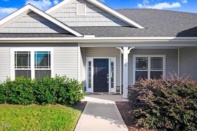 property entrance featuring a shingled roof and a porch