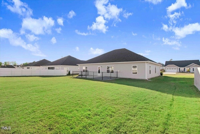 rear view of house with a lawn and a fenced backyard