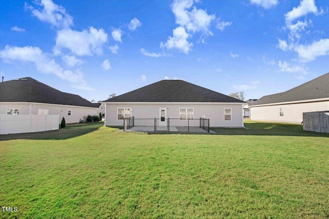 back of house featuring a yard and fence