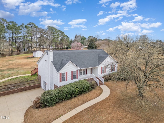 view of front facade featuring a garage, driveway, a porch, and fence