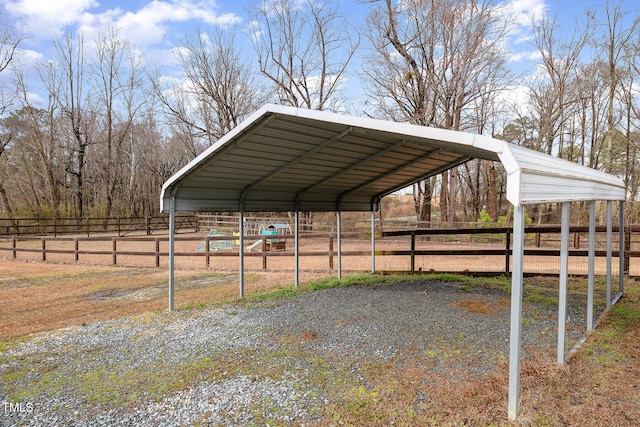 view of parking / parking lot featuring a detached carport and fence