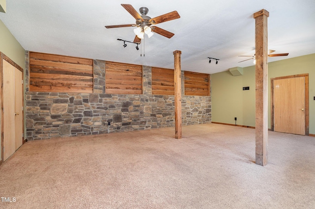 carpeted empty room featuring ceiling fan, ornate columns, a textured ceiling, and track lighting