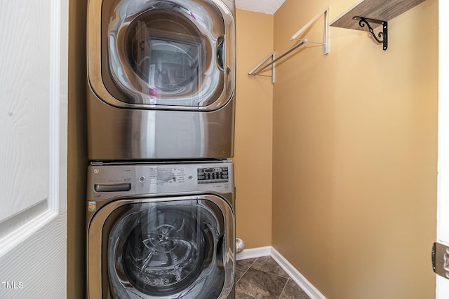 laundry area with stacked washing maching and dryer, laundry area, and baseboards