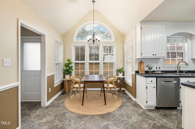 dining space featuring an inviting chandelier, stone finish flooring, baseboards, and vaulted ceiling