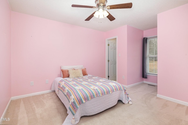 bedroom featuring light colored carpet, ceiling fan, visible vents, and baseboards