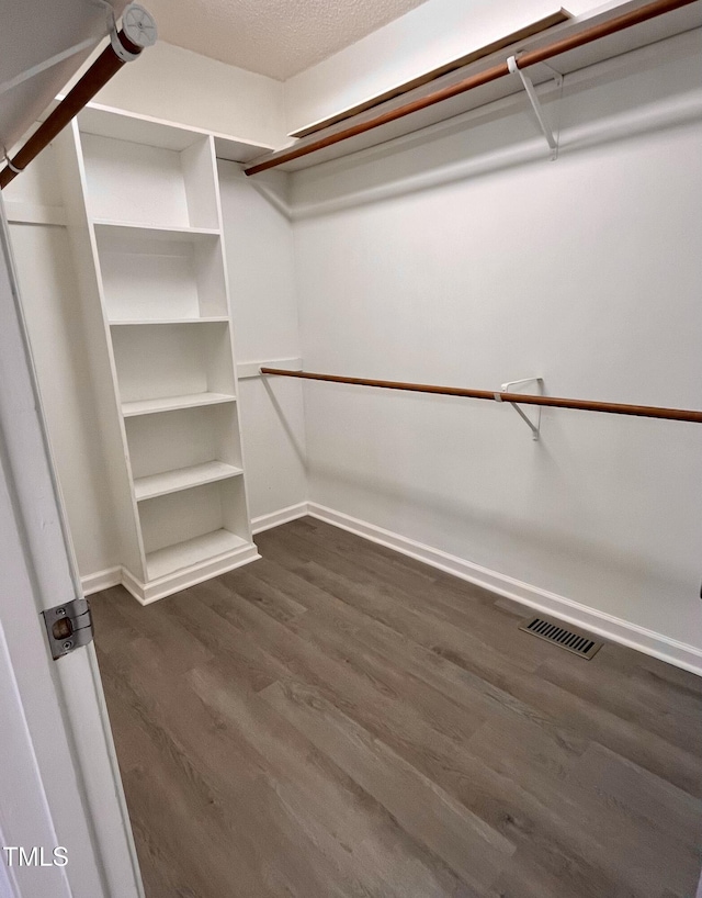 walk in closet with dark wood-type flooring and visible vents