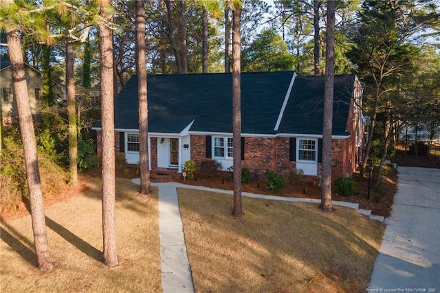 view of front of house with a shingled roof and brick siding