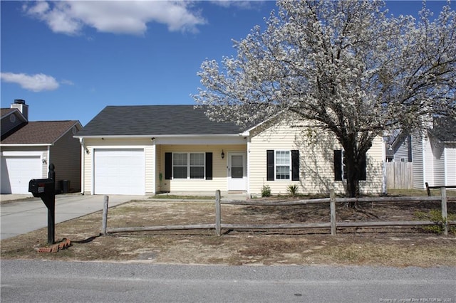 view of front of house featuring driveway, an attached garage, and fence