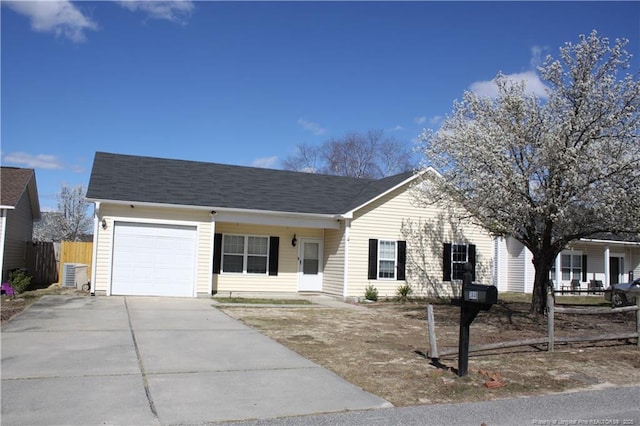 ranch-style home featuring driveway, an attached garage, and fence