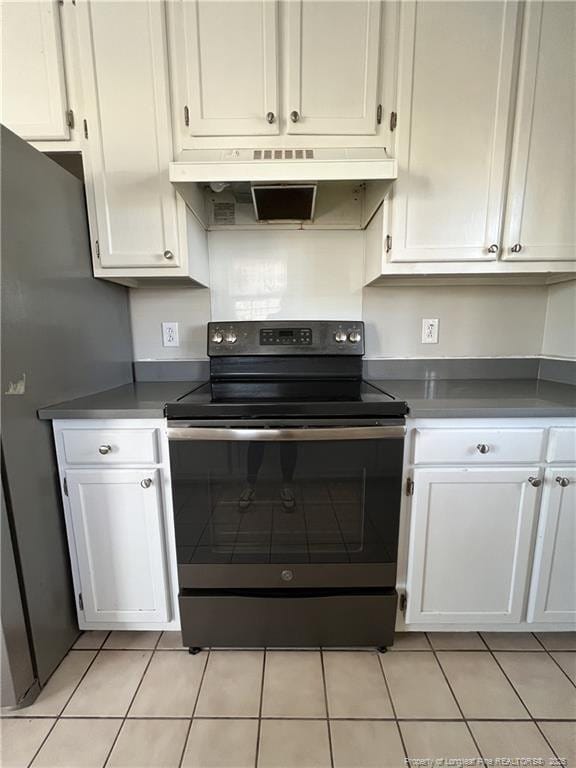 kitchen with under cabinet range hood, white cabinets, and range with electric stovetop