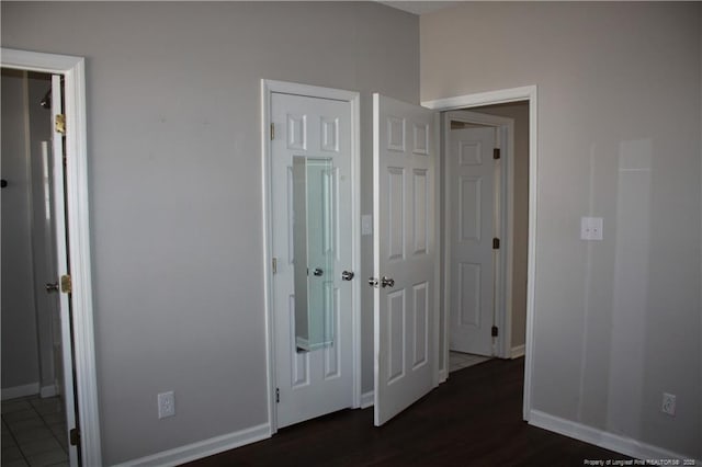 hallway with baseboards and dark wood-type flooring