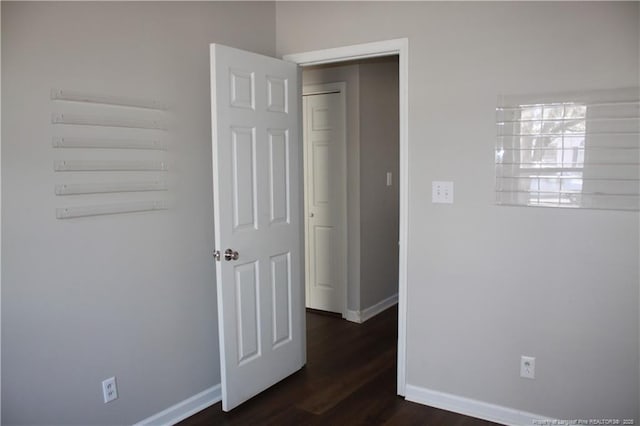 interior space with dark wood-style flooring and baseboards