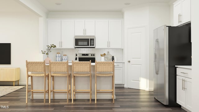 kitchen featuring dark wood-type flooring, a kitchen breakfast bar, appliances with stainless steel finishes, decorative backsplash, and crown molding