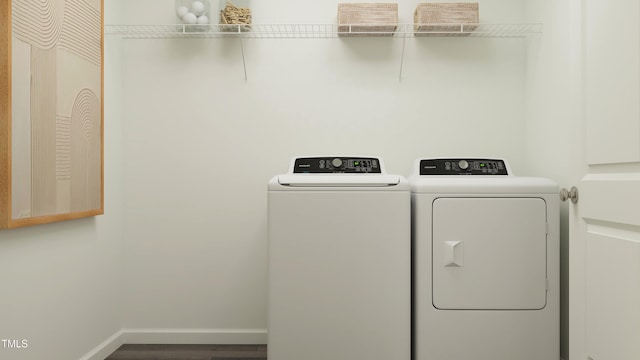 laundry area featuring laundry area, baseboards, wood finished floors, and washing machine and clothes dryer