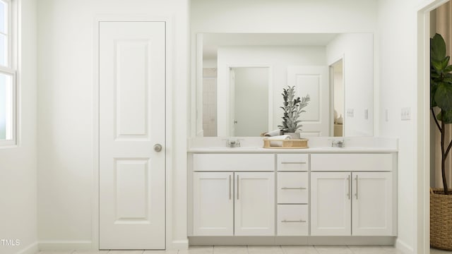 bathroom with double vanity, baseboards, and a sink