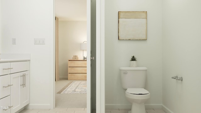 bathroom featuring toilet, vanity, and baseboards