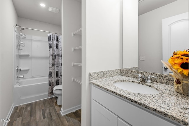 bathroom with toilet, wood finished floors, vanity, baseboards, and shower / bath combo with shower curtain