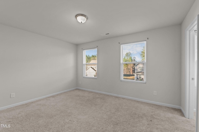 carpeted spare room featuring visible vents and baseboards