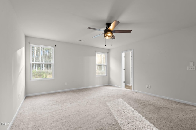 empty room featuring carpet floors, baseboards, and a ceiling fan