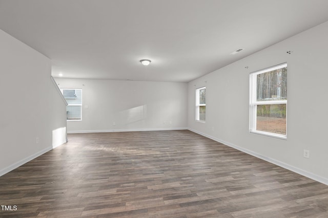 unfurnished room featuring visible vents, baseboards, and wood finished floors